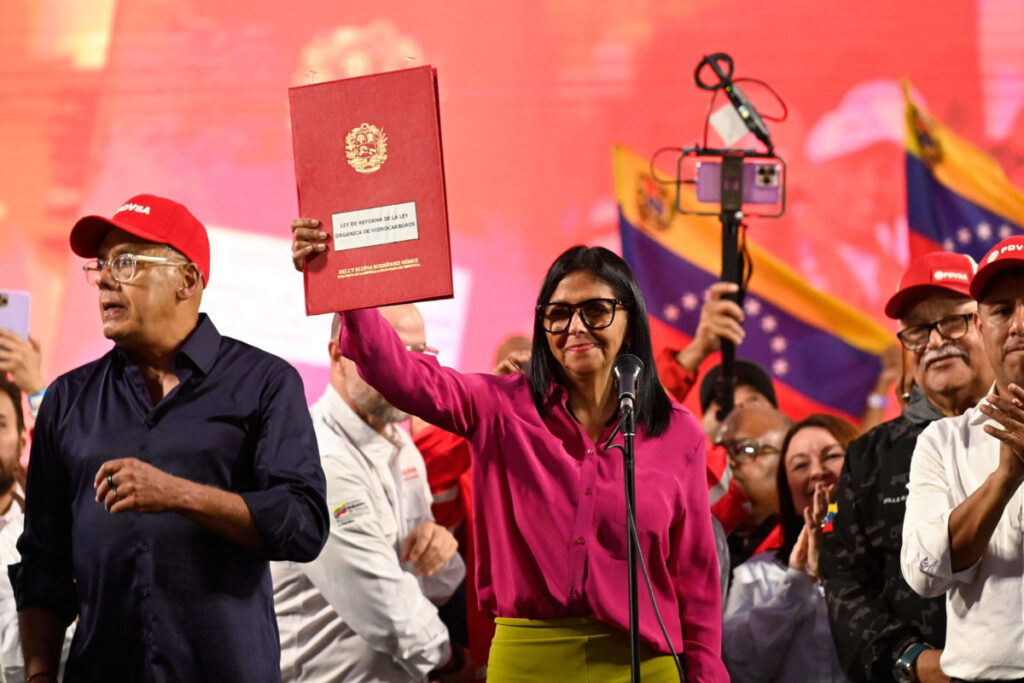 Acting President Delcy Rodriguez holds up the document of the partial reform of the Organic Hydrocarbons Law (LOH) in front of a crowd. Photo: Maxwell Briceno/Reuters.