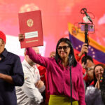 Acting President Delcy Rodriguez holds up the document of the partial reform of the Organic Hydrocarbons Law (LOH) in front of a crowd. Photo: Maxwell Briceno/Reuters.