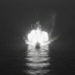 Digital illustration of a speedboat being targeted by the US in a "kinetic strike" on the high seas. This image was generated using artificial intelligence (AI) to represent military infrared surveillance footage released by US Southern Command following its Febuary 20, 2026, extrajudicial killing. Photo: Orinoco Tribune via Google AI.