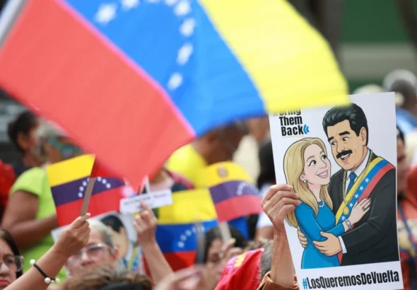 Demonstrators in Caracas hold a banner depicting Venezuelan President Nicolás Maduro and First Lady Cilia Flores with the slogan "Bring Them Back," demanding their release from illegal US imprisonment. Photo: Telesur.