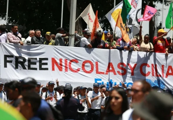 Marchers in Plaza Bolívar, Caracas, Venezuela, hold a banner demanding freedom for President Nicolás Maduro and First Lady Cilia Flores from US imprisonment. Photo: Telesur.