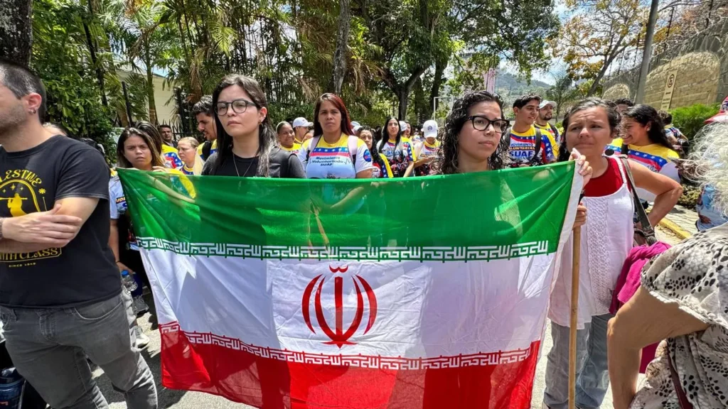 Marchers hold the flag of Iran as they proceed through Caracas, repudiating the US-Zionist aggression on Iran. Photo: José Negrón Valera/Sputnik.