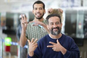 Repatriated Venezuelan migrant does President Nicolas Maduro's victory sign, popularized after the US kidnapping, while waiting to pass migration in the Simón Bolívar International Airport in Maiquetía, La Guaira state, on March 11, 2026. Photo: IG/@minjusticia_ve.