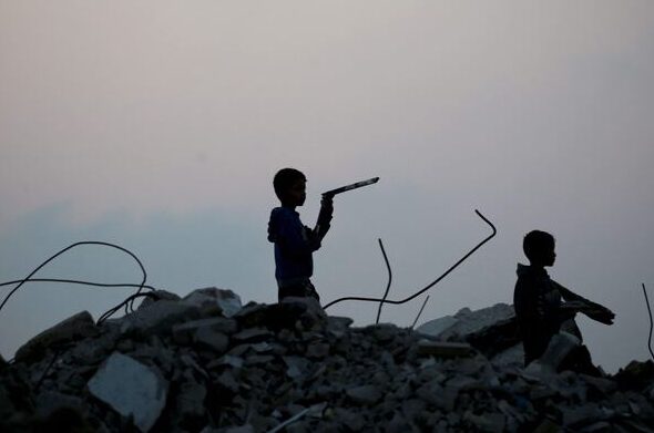 Displaced Palestinian children stand amid the rubble of buildings destroyed during the Israeli bombing of Gaza, at dusk over the Bureij refugee camp in the central Gaza Strip, on November 10, 2025. Photo: Eyad Baba/AFP.