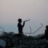 Displaced Palestinian children stand amid the rubble of buildings destroyed during the Israeli bombing of Gaza, at dusk over the Bureij refugee camp in the central Gaza Strip, on November 10, 2025. Photo: Eyad Baba/AFP.