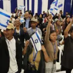 Members of the Bnei Menashe (Sons of Manasseh) community from India wave Israeli flags as they arrive at Ben Gurion Airport in Lod, near Tel Aviv, on April 23, 2026. Photo: Jack Guez/AFP.