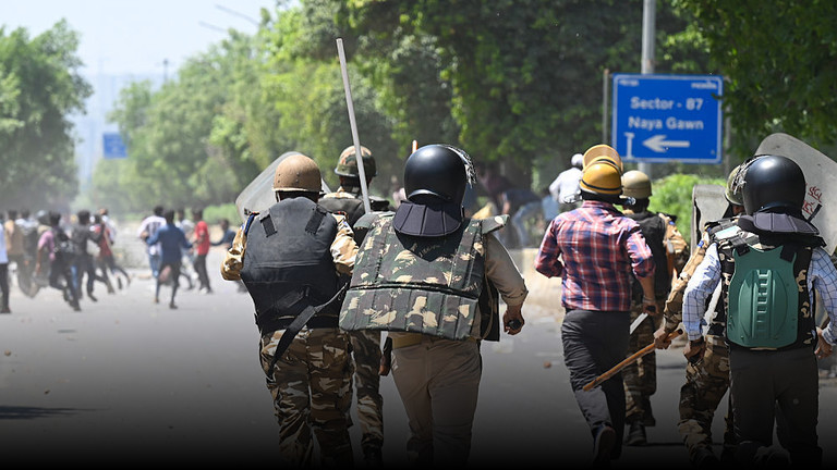 Police charge during a protest by workers over wage hike demands in Noida, India. Photo: Sunil Ghosh/Getty Images/Hindustan Times.