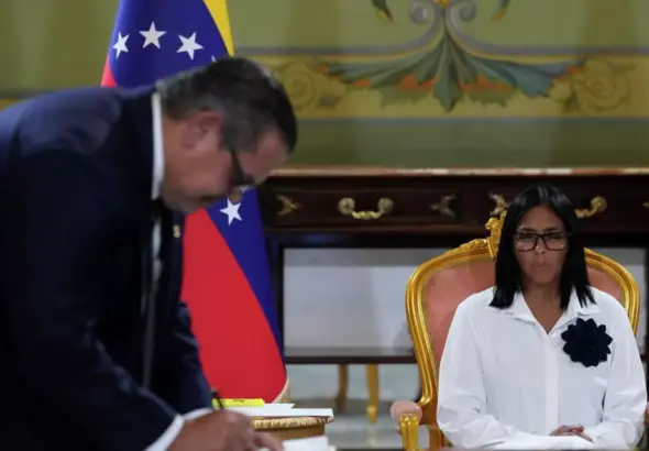 Venezuelan Acting President Delcy Rodríguez looks on as the Chevron representative in Venezuela, Javier La Rosa, signs the latest PDVSA-Chevron agreement. Photo: AP/Ariana Cubillos.