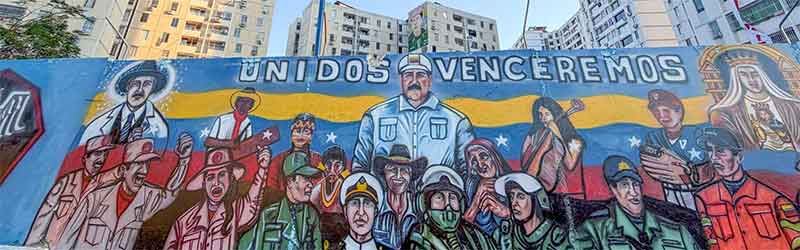 A mural in Venezuela, featuring prominent political figures and the text "UNIDOS VENCEREMOS". Photo: CounterCurrents.