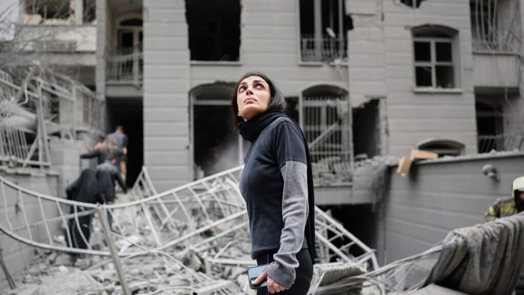 An Iranian walking amongst damaged buildings. Photo: AP/Sajad Safari.