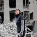 An Iranian walking amongst damaged buildings. Photo: AP/Sajad Safari.