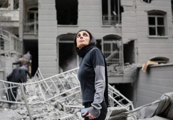 An Iranian walking amongst damaged buildings. Photo: AP/Sajad Safari.