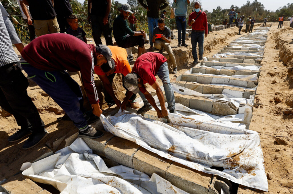 People bury the unidentified bodies of Palestinians who had been held in Israel during the war, after they were handed over by Israel in Deir Al-Balah, central Gaza, on 22 October 2025. Photo: Reuters/Mahmoud Issa.