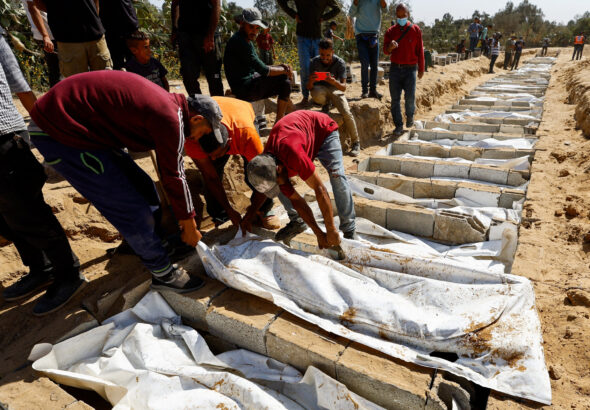 People bury the unidentified bodies of Palestinians who had been held in Israel during the war, after they were handed over by Israel in Deir Al-Balah, central Gaza, on 22 October 2025. Photo: Reuters/Mahmoud Issa.