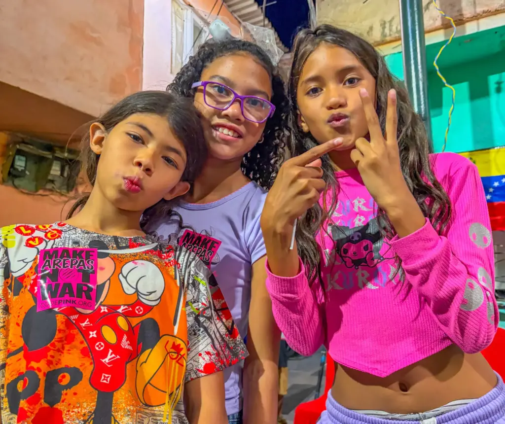 CAPTION: Children at the El Panal Commune in Caracas flash the Maduro victory sign. Photo: Roger D. Harris.