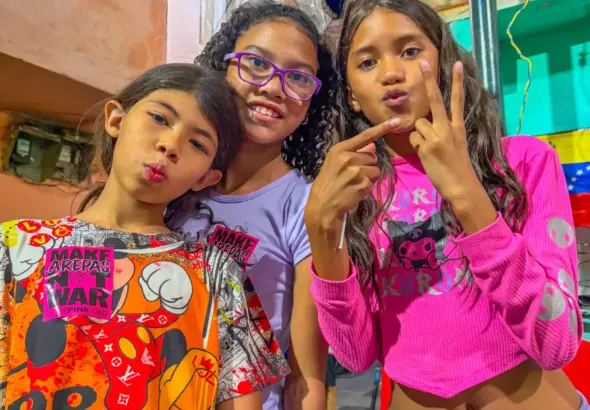 CAPTION: Children at the El Panal Commune in Caracas flash the Maduro victory sign. Photo: Roger D. Harris.