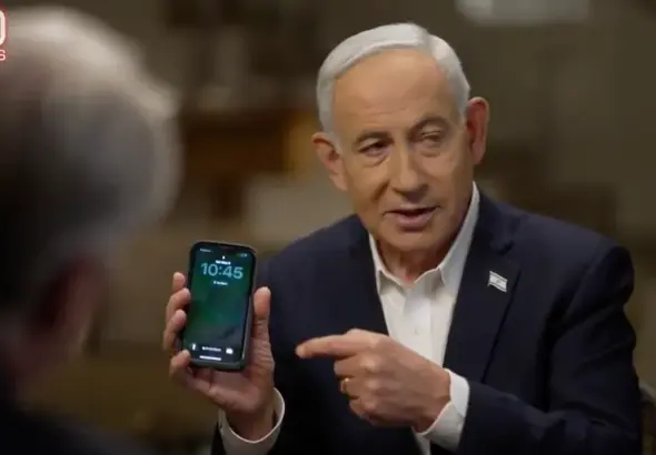 Benjamin Netanyahu holds up a mobile phone during an interview on 60 Minutes on May 11, 2026. Photo: Caitlin Johnstone/file photo.