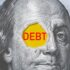 The word "DEBT" written in red on a US dollar bill. Photo: Shutterstock.