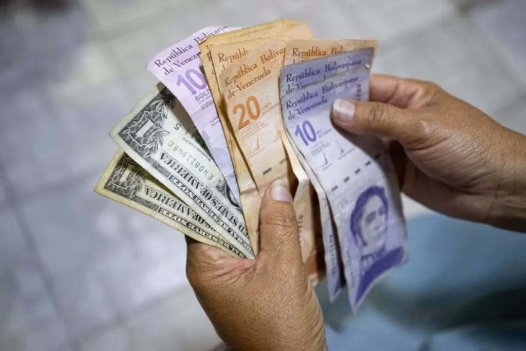 A person holds bolívar and dollar bills. File photo.