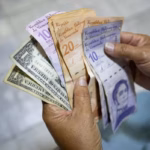 A person holds bolívar and dollar bills. File photo.
