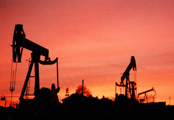 Silhouette of oil rigs against a sunset sky. Photo: Bob Riha, Jr./Getty Images.