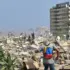 A person wearing a backpack with the colors of the Venezuelan flag standing amongst the rubble of collapsed buildings in La Guaira state, Venezuela, after the series of earthquakes on June 24, 2026. Photo: Reuters.