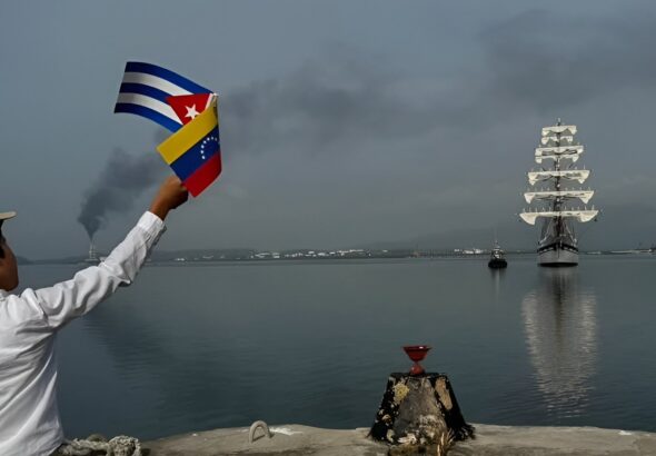 A person waves small Cuban and Venezuelan flags upon the arrival of the Simón Bolívar Training Ship at Santiago de Cuba, Cuba, on June 4, 2026. Photo: X/@Cancilleria_ve.