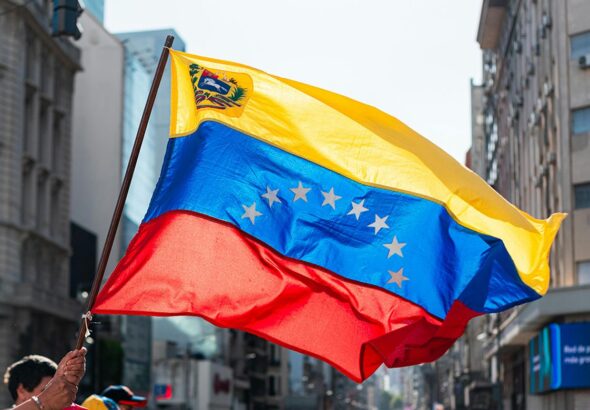 A person waves the Venezuelan flag in a Caracas street. Photo: Alex Dos Santos/Pexels/file photo.