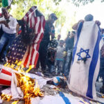 Protesters burn US and Israeli flags in Caracas, July 24, 2026. Photo: Maxwell Briceño/AFP.