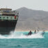 Yemeni fishermen pass by a commercial ship at the strategic Bab al-Mandeb Strait. Photo: AP.