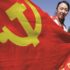 A woman holding the flag of the Communist Party of China, which is characterized by a red field with a yellow hammer and sickle in the upper left corner. Photo: Andy Wong/AP.