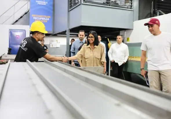 Acting President Delcy Rodríguez shakes hands with a worker at a factory visit. Photo: Venezuelan Presidential Press.