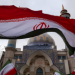 Iranian pro-government protesters wave national flags while participating in an anti-war protest gathering against the US and Israeli military attacks in Iran, in Tehran, Iran, on February 28, 2026. Photo: Morteza Nikoubazl/NurPhoto via Getty Images.