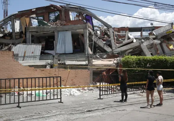 People look at a building destroyed by the 7.4 magnitude earthquake in Cali, Colombia. Photo: EFE/Ernesto Guzmán.