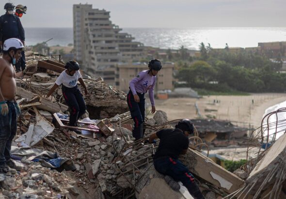 Emergency responders trying to recover casualties in a collapsed building in Catia La Mar, La Guaira state, Venezuela. Photo: ANSA/EPA.