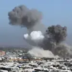 A screenshot from a video shows the aftermath of an Israeli strike on a café in Gaza City, with smoke rising and debris scattered. Photo: Quds News Network.