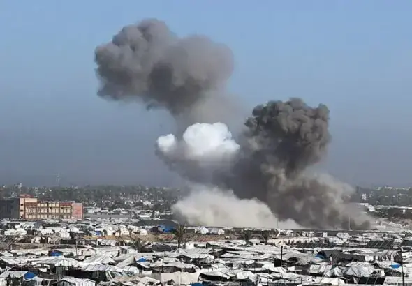 A screenshot from a video shows the aftermath of an Israeli strike on a café in Gaza City, with smoke rising and debris scattered. Photo: Quds News Network.