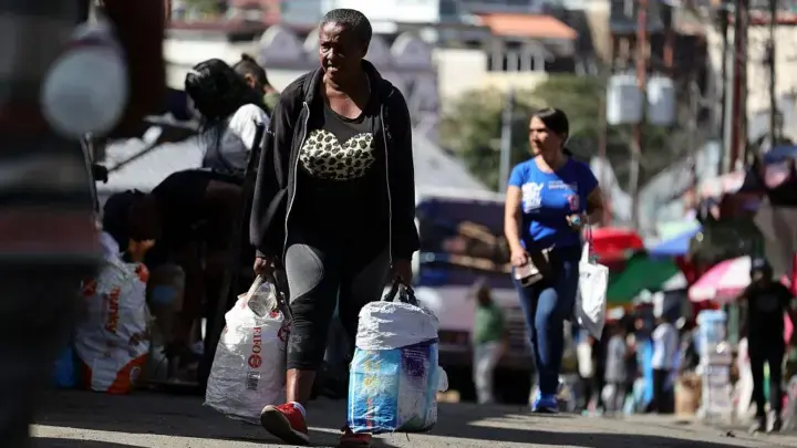 A woman carries bags while shopping at a street market in the Petare neighborhood of Caracas, Venezuela, January 8, 2026. Photo: Jesús Vargas/Getty Images/file photo.